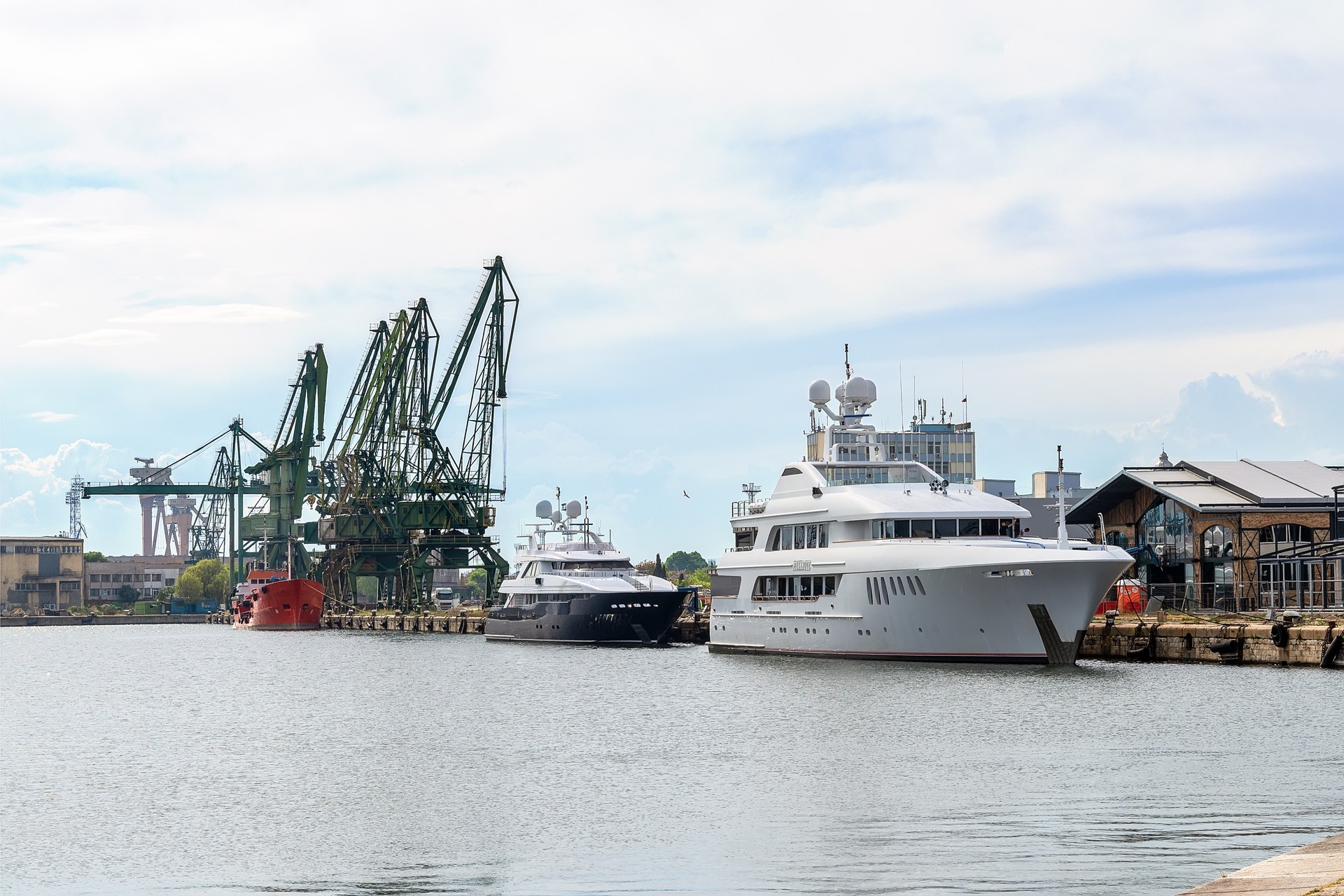 The charter yacht Mustique in the port of Varna, Bulgaria. Two luxury yachts moored at the pier on a spring day. Expensive super yacht front view. Trinity yachts.